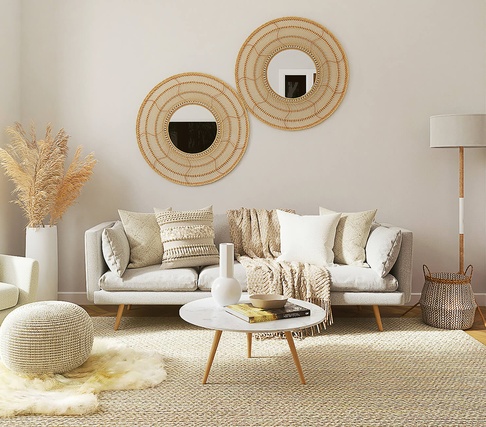 Wohnraum mit Couch, Wandspiegeln, Couchtisch, Teppich und Lampe